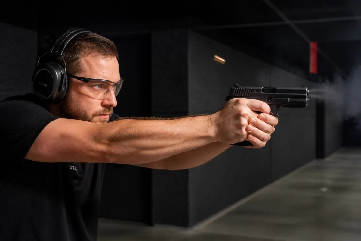 Atirador disparando pistola Glock 9mm em estande de tiro